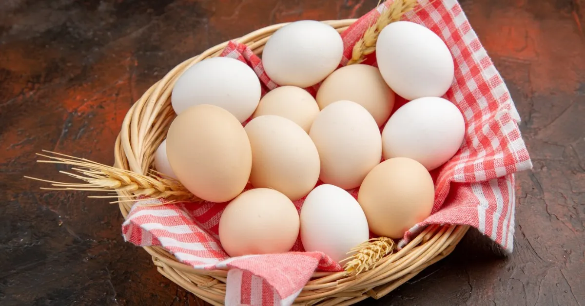 Eggs for baking inside basket with towel on a dark surface