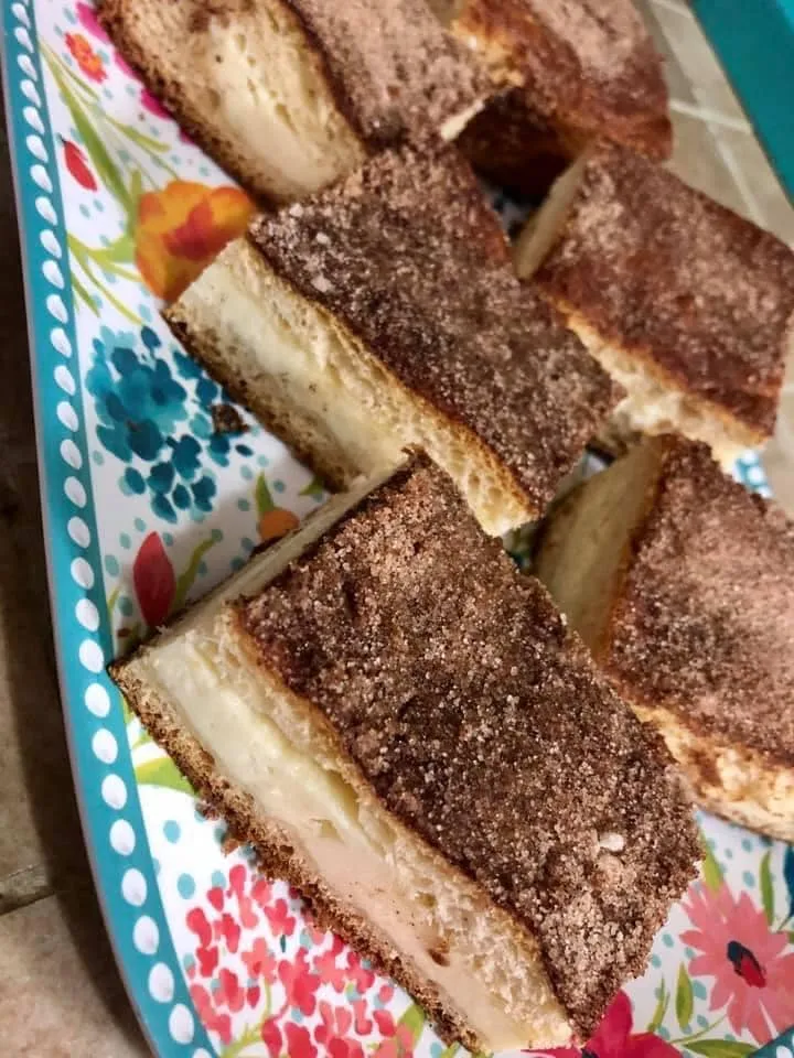 churro cheesecake bars on a floral plate.