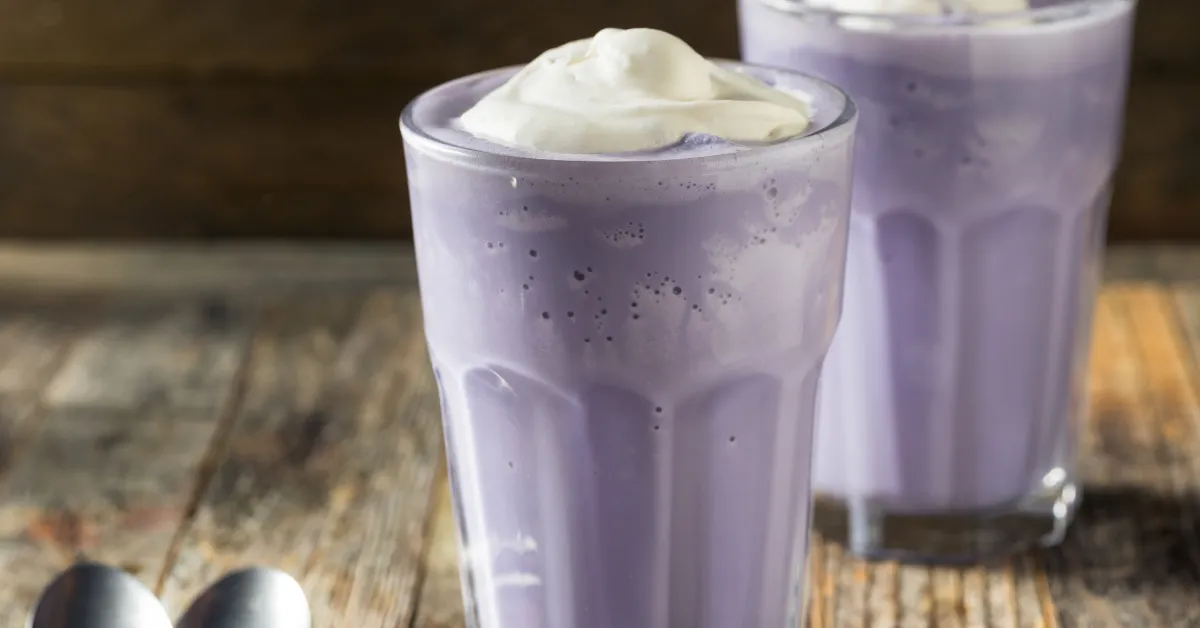 Purple milkshake with whipped cream on top, high in sugar and calories.