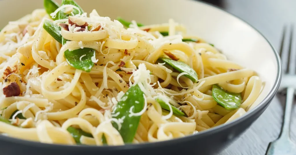 A delectable bowl of creamy Cacio e Pepe, perfectly cooked spaghetti coated in a rich, smooth cheese sauce, garnished with freshly cracked black pepper.