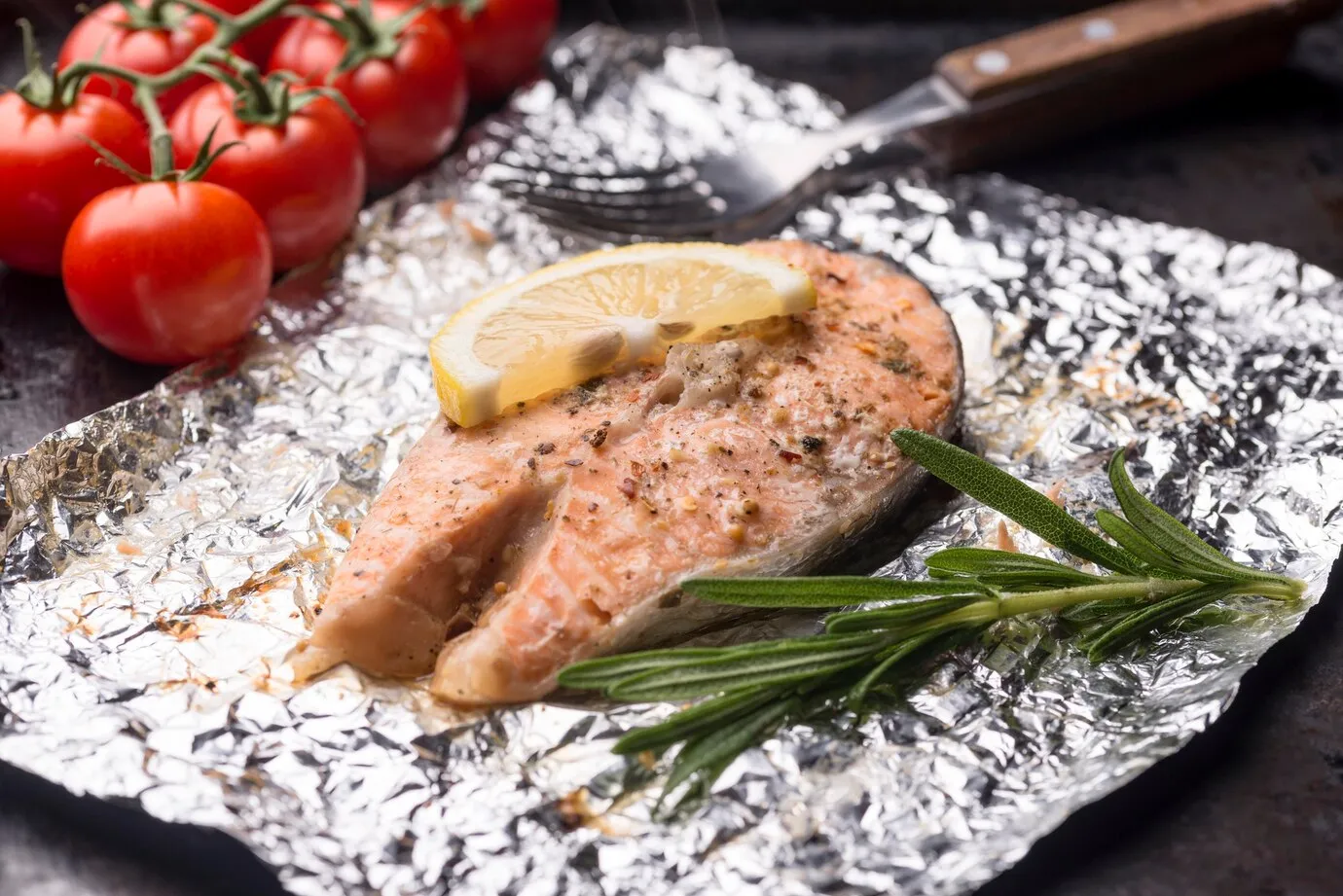 slice of salmon in a foil and tomato
