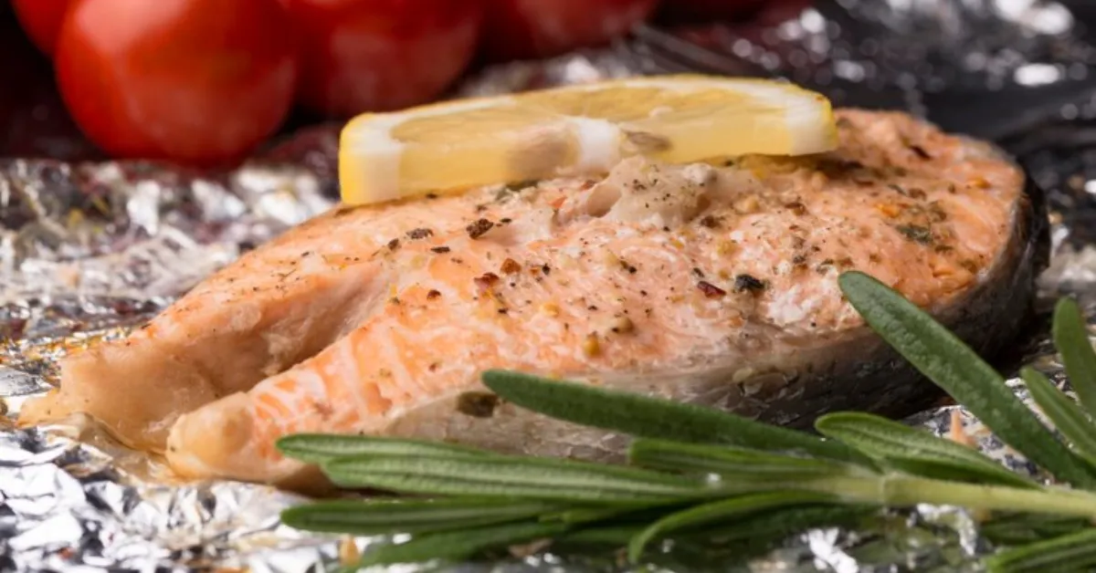 slice of seafood salmon in foil and tomatoes
