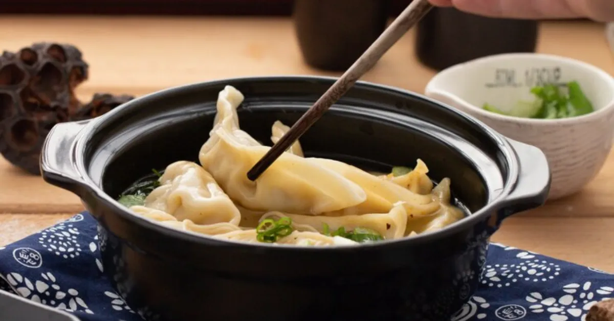a close-up of the dish, which is visually appealing and shows off the key ingredients: wonton dumplings, chili sauce, and soy sauce.