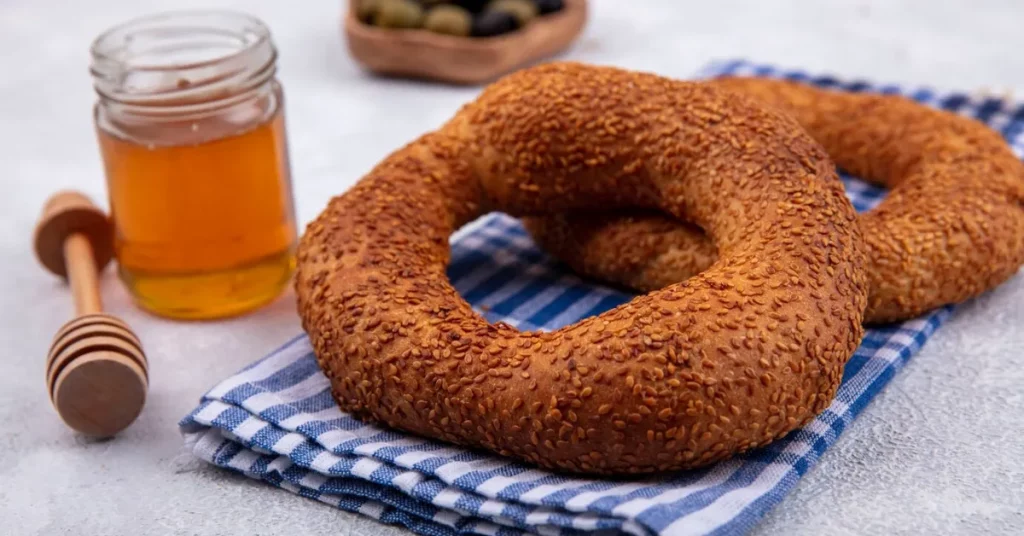 Delicious and soft bagels isolated on a checked cloth with honey.