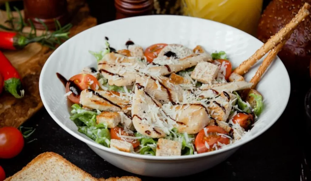 classic chicken caesar salad with grated parmesan and crackers