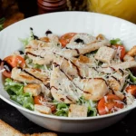 classic chicken caesar salad with grated parmesan and crackers